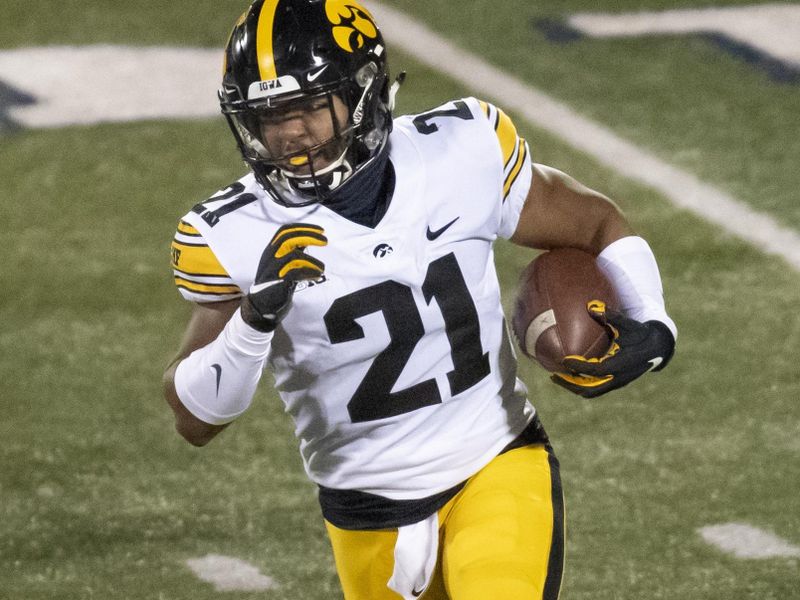 Dec 5, 2020; Champaign, Illinois, USA; Iowa Hawkeyes running back Ivory Kelly-Martin (21) runs the ball against the Illinois Fighting Illini during the second half at Memorial Stadium. Mandatory Credit: Patrick Gorski-USA TODAY Sports