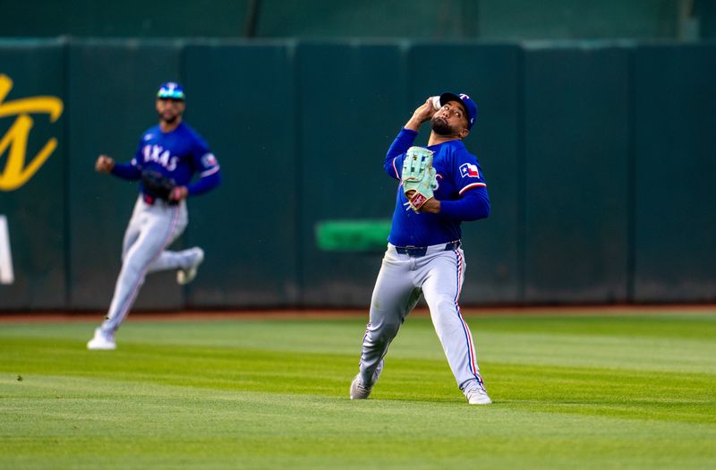 May 6, 2024; Oakland, California, USA; Texas Rangers first baseman Ezequiel Duran (20) after fielding a fly ball attempts to throw out Oakland Athletics first baseman J.D. Davis (not pictured) during the second inning at Oakland Alameda County Coliseum. Mandatory Credit: Neville E. Guard-USA TODAY Sports