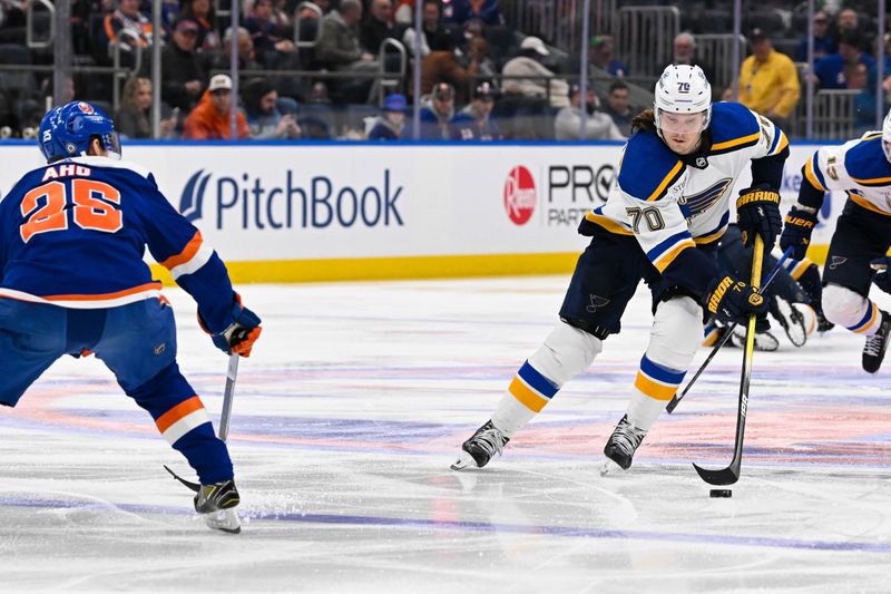 Mar 5, 2024; Elmont, New York, USA;  St. Louis Blues center Oskar Sundqvist (70) skates against New York Islanders defenseman Sebastian Aho (25) during the third period at UBS Arena. Mandatory Credit: Dennis Schneidler-USA TODAY Sports