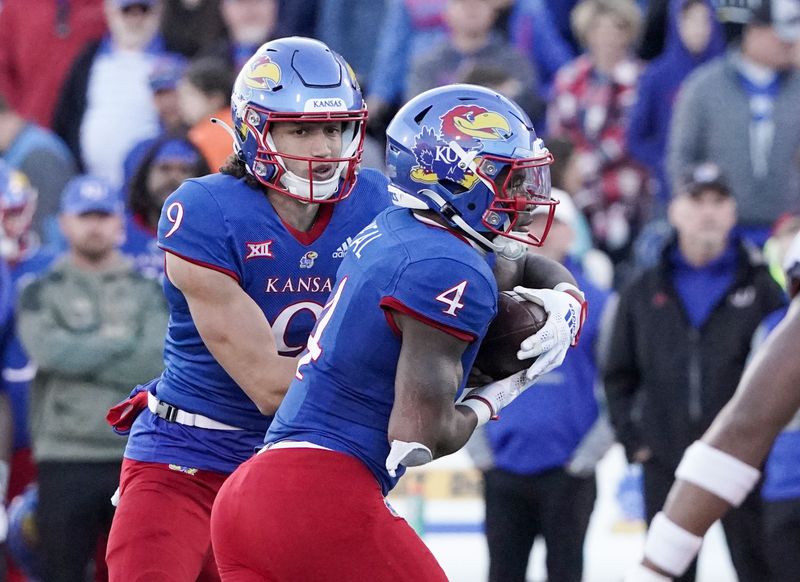 Nov 5, 2022; Lawrence, Kansas, USA; Kansas Jayhawks quarterback Jason Bean (9) hands off to running back Devin Neal (4) against the Oklahoma State Cowboys during the second half of the game at David Booth Kansas Memorial Stadium. Mandatory Credit: Denny Medley-USA TODAY Sports