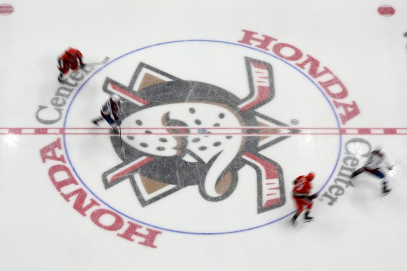 Apr 13, 2025; Anaheim, California, USA; Colorado Avalanche and Anaheim Ducks players skate across the Ducks logo at center ice in the second period at Honda Center. Mandatory Credit: Kirby Lee-Imagn Images