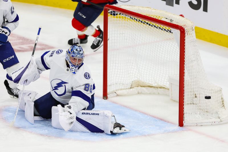 Apr 23, 2024; Sunrise, Florida, USA; Tampa Bay Lightning goaltender Andrei Vasilevskiy (88) watches as the puck goes past the net against the Florida Panthers during overtime in game two of the first round of the 2024 Stanley Cup Playoffs at Amerant Bank Arena. Mandatory Credit: Sam Navarro-USA TODAY Sports