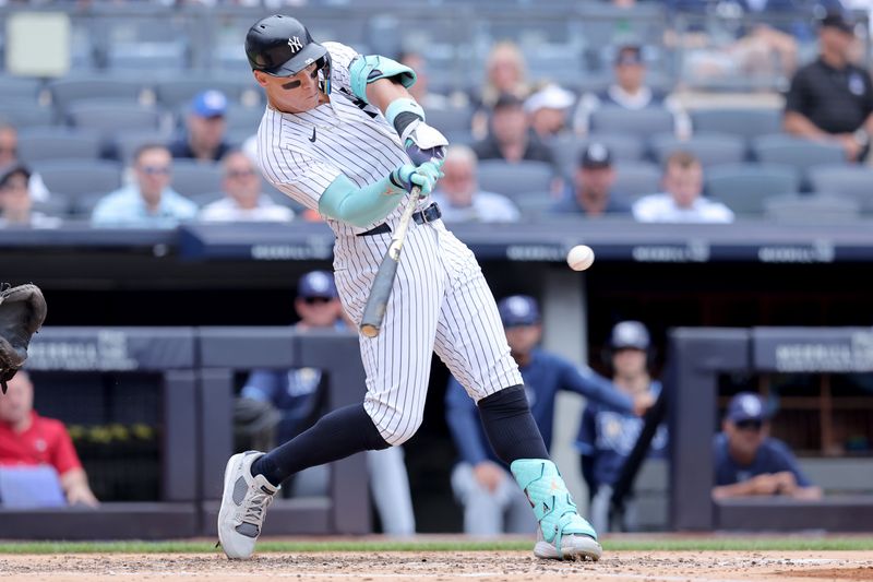 Jul 22, 2024; Bronx, New York, USA; New York Yankees designated hitter Aaron Judge (99) hits a single against the Tampa Bay Rays during the fourth inning at Yankee Stadium. Mandatory Credit: Brad Penner-USA TODAY Sports