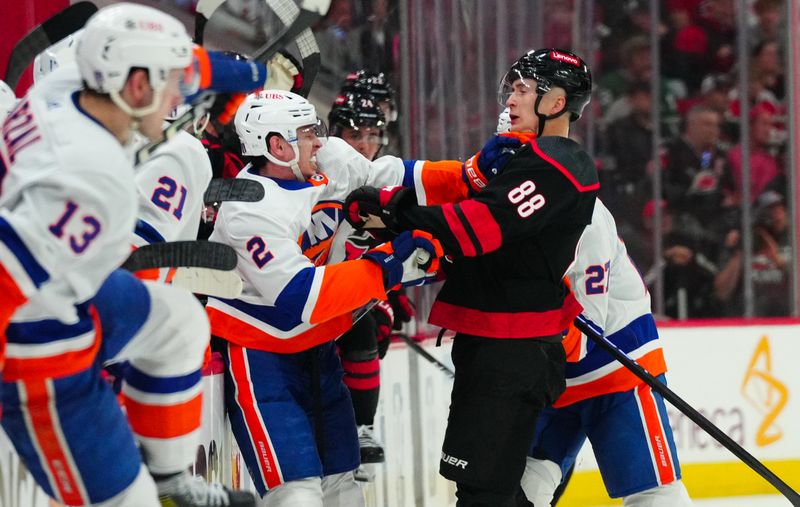 Apr 20, 2024; Raleigh, North Carolina, USA; New York Islanders defenseman Mike Reilly (2) and Carolina Hurricanes center Martin Necas (88) battle between the bench during the third period in game one of the first round of the 2024 Stanley Cup Playoffs at PNC Arena. Mandatory Credit: James Guillory-USA TODAY Sports