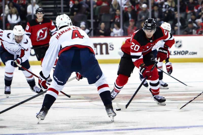 Nov 10, 2023; Newark, New Jersey, USA; New Jersey Devils center Michael McLeod (20) skates with the puck against Washington Capitals defenseman Hardy Haman Aktell (4) during the second period at Prudential Center. Mandatory Credit: John Jones-USA TODAY Sports