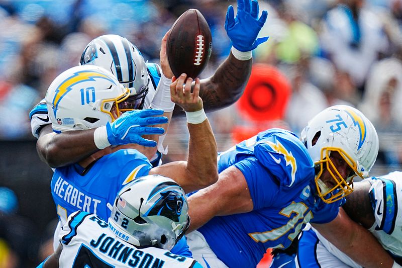 Los Angeles Chargers quarterback Justin Herbert fumbles against the Carolina Panthers during the second half of an NFL football game on Sunday, Sept. 15, 2024, in Charlotte, N.C. (AP Photo/Rusty Jones)