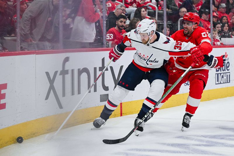 Feb 27, 2024; Detroit, Michigan, USA; Washington Capitals right wing Anthony Mantha (39) and Detroit Red Wings left wing David Perron (57) battle for the puck during the first period at Little Caesars Arena. Mandatory Credit: Tim Fuller-USA TODAY Sports