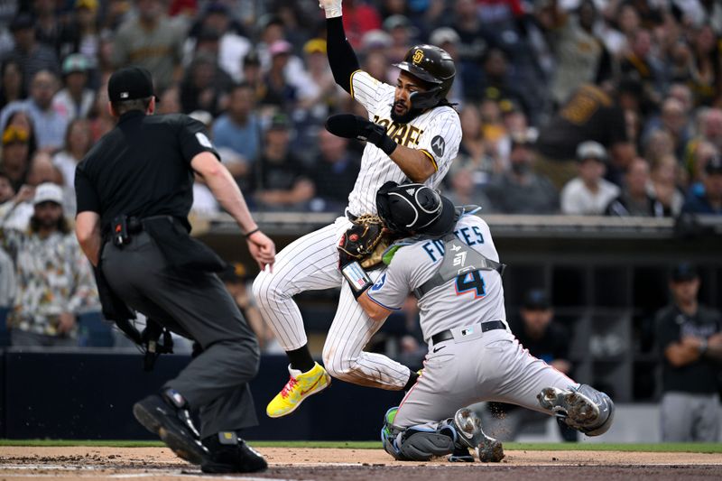 Aug 21, 2023; San Diego, California, USA; San Diego Padres right fielder Fernando Tatis (23) is tagged out at home plate by Miami Marlins catcher Nick Fortes (4) during the first inning at Petco Park. Mandatory Credit: Orlando Ramirez-USA TODAY Sports