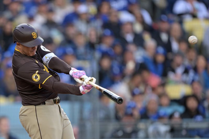 Apr 14, 2024; Los Angeles, California, USA; San Diego Padres third base Manny Machado (13) hits a solo home run in the fourth inning against the Los Angeles Dodgers at Dodger Stadium. Mandatory Credit: Jayne Kamin-Oncea-USA TODAY Sports