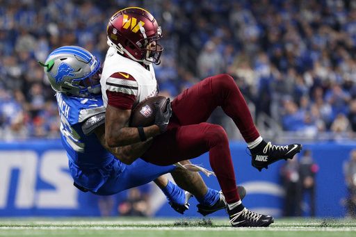 Detroit Lions safety Brian Branch (32) tackles Washington Commanders wide receiver Dyami Brown (2) during the second half of an NFL football divisional playoff game, Saturday, Jan. 18, 2025, in Detroit. (AP Photo/Mike Mulholland)