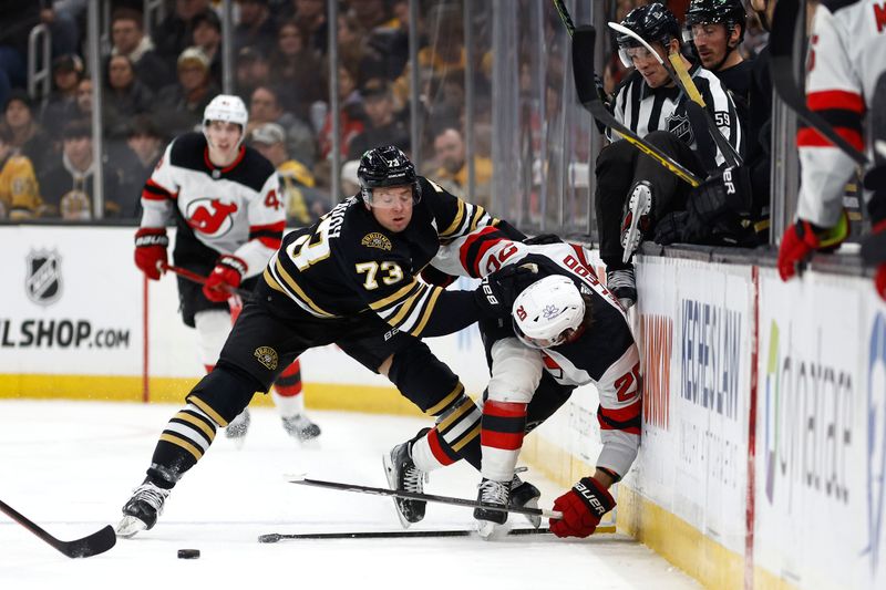 Jan 15, 2024; Boston, Massachusetts, USA; Boston Bruins defenseman Charlie McAvoy (73) knocks New Jersey Devils center Michael McLeod (20) off the puck during the second period at TD Garden. Mandatory Credit: Winslow Townson-USA TODAY Sports