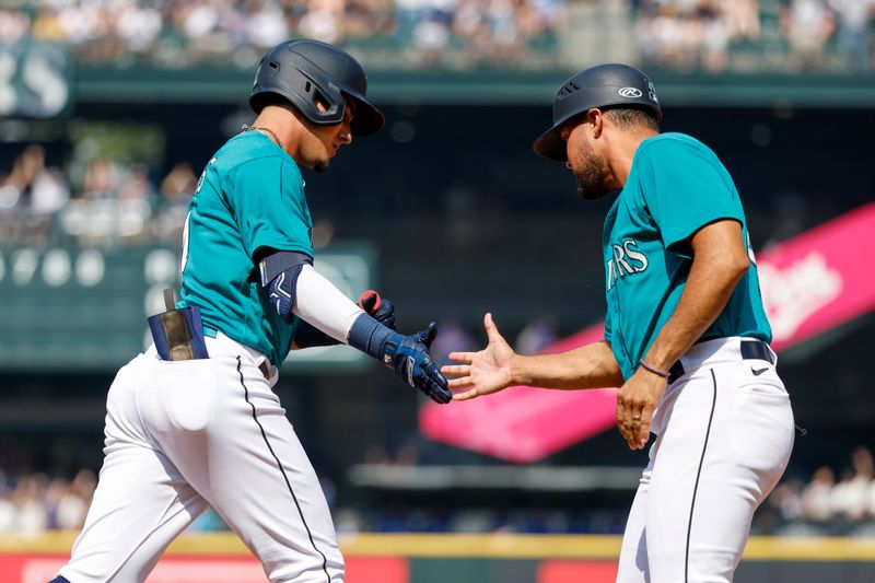 Aug 28, 2023; Seattle, Washington, USA; Seattle Mariners second baseman Josh Rojas (4, left) shakes hands with first base coach Kristopher Negr  n (45) after hitting a solo-home run against the Kansas City Royals during the third inning at T-Mobile Park. Mandatory Credit: Joe Nicholson-USA TODAY Sports