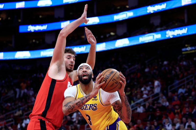 HOUSTON, TEXAS - JANUARY 29: Anthony Davis #3 of the Los Angeles Lakers drives to the net ahead of Alperen Sengun #28 of the Houston Rockets during the first half at Toyota Center on January 29, 2024 in Houston, Texas. NOTE TO USER: User expressly acknowledges and agrees that, by downloading and or using this photograph, User is consenting to the terms and conditions of the Getty Images License Agreement.? (Photo by Carmen Mandato/Getty Images)