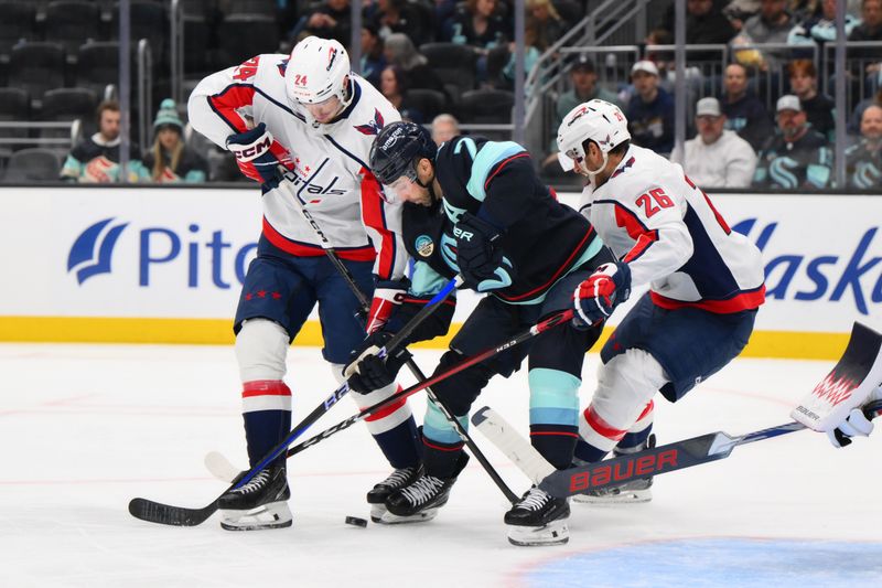 Mar 14, 2024; Seattle, Washington, USA; Washington Capitals center Connor McMichael (24) and Seattle Kraken right wing Jordan Eberle (7) and Washington Capitals right wing Nic Dowd (26) play the puck during the second period at Climate Pledge Arena. Mandatory Credit: Steven Bisig-USA TODAY Sports