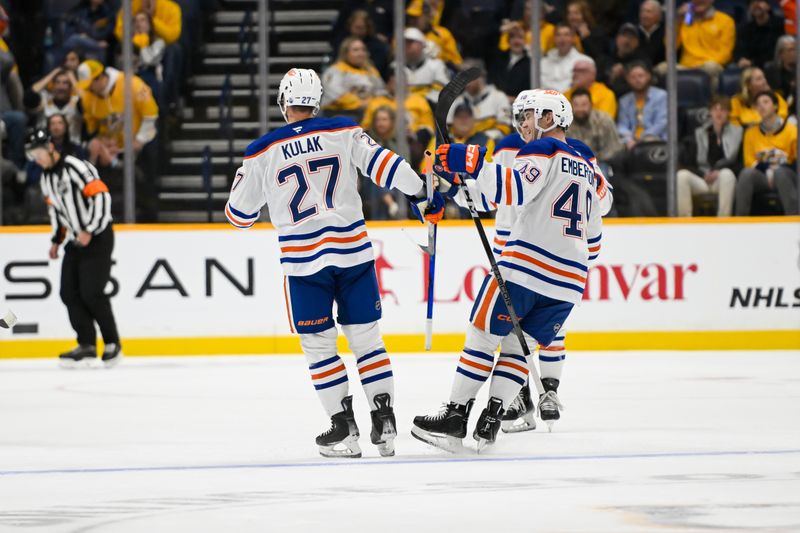 Oct 17, 2024; Nashville, Tennessee, USA;  Edmonton Oilers defenseman Brett Kulak (27) celebrates his goal with defenseman Ty Emberson (49) against the Nashville Predators during the first period at Bridgestone Arena. Mandatory Credit: Steve Roberts-Imagn Images