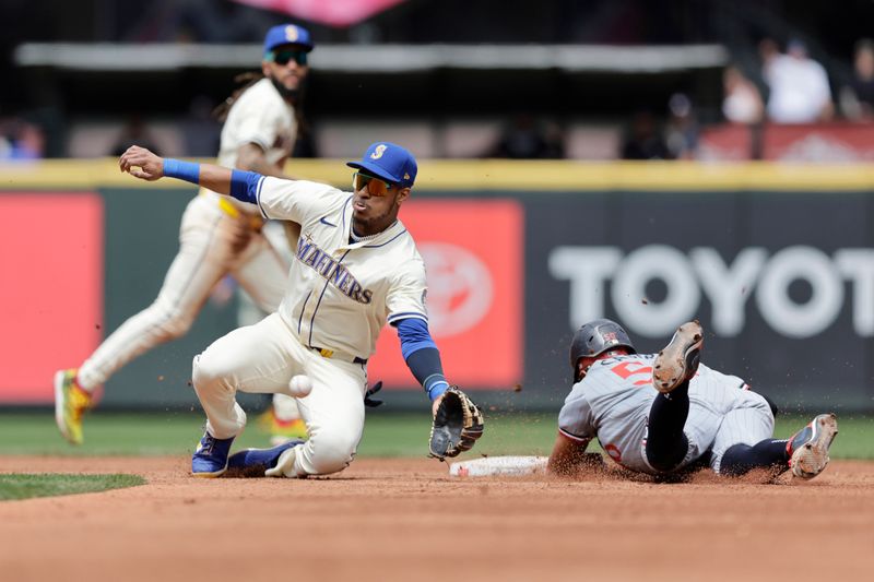 Jun 30, 2024; Seattle, Washington, USA; Seattle Mariners second baseman Jorge Polanco (7) reaches for the throw as Minnesota Twins shortstop Willi Castro (50) steals second during the third inning at T-Mobile Park. Mandatory Credit: John Froschauer-USA TODAY Sports