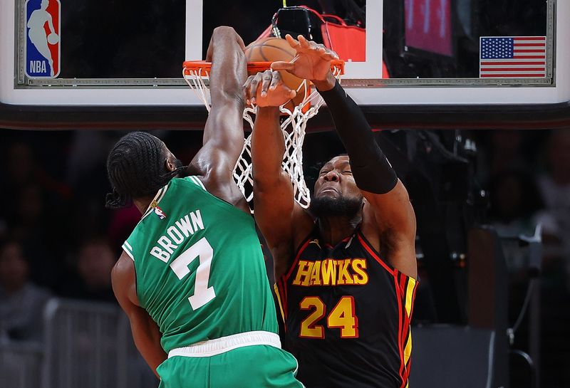 ATLANTA, GEORGIA - MARCH 28:  Jaylen Brown #7 of the Boston Celtics dunks over Bruno Fernando #24 of the Atlanta Hawks during third quarter at State Farm Arena on March 28, 2024 in Atlanta, Georgia.  NOTE TO USER: User expressly acknowledges and agrees that, by downloading and/or using this photograph, user is consenting to the terms and conditions of the Getty Images License Agreement.  (Photo by Kevin C. Cox/Getty Images)