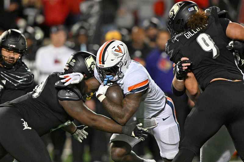 Nov 9, 2023; Louisville, Kentucky, USA; Virginia Cavaliers running back Kobe Pace (5) runs the ball against Louisville Cardinals defensive lineman Dezmond Tell (99) during the second half at L&N Federal Credit Union Stadium. Louisville defeated Virginia 31-24. Mandatory Credit: Jamie Rhodes-USA TODAY Sports