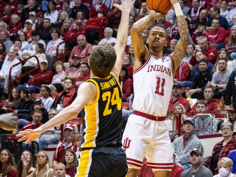 Jan 30, 2024; Bloomington, Indiana, USA; Indiana Hoosiers guard CJ Gunn (11) shoots the ball while Iowa Hawkeyes forward Pryce Sandfort (24) defends in the first half at Simon Skjodt Assembly Hall. Mandatory Credit: Trevor Ruszkowski-USA TODAY Sports