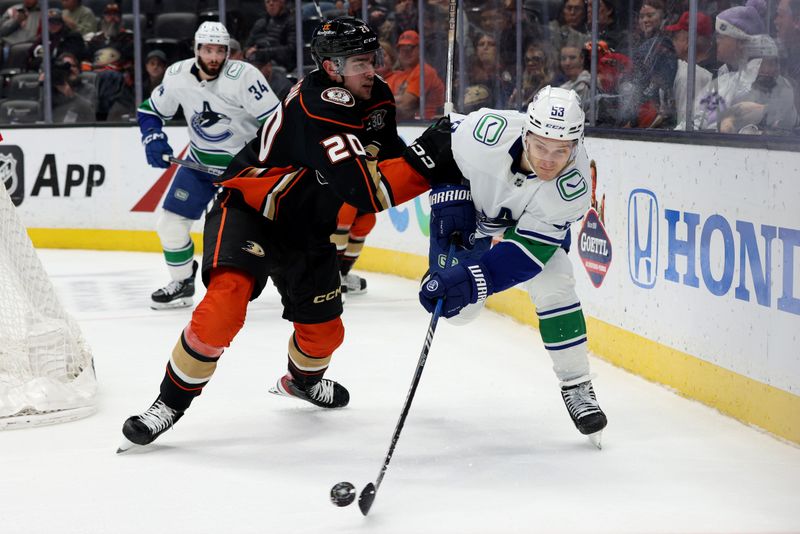 Mar 3, 2024; Anaheim, California, USA; Vancouver Canucks center Teddy Blueger (53) passes against Anaheim Ducks right wing Brett Leason (20) during the third period at Honda Center. Mandatory Credit: Jason Parkhurst-USA TODAY Sports