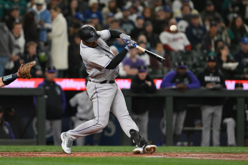 Apr 15, 2023; Seattle, Washington, USA; Colorado Rockies third baseman Elehuris Montero hits an RBI single against the Seattle Mariners during the second inning at T-Mobile Park. Mandatory Credit: Steven Bisig-USA TODAY Sports