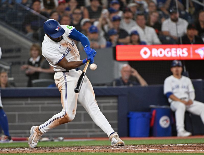 Aug 11, 2024; Toronto, Ontario, CAN; Toronto Blue Jays third base Luis De Los Santos (20) hits a RBI double in the eighth inning against the Oakland Athletics at Rogers Centre. Mandatory Credit: Gerry Angus-USA TODAY Sports