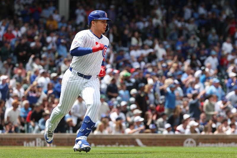 May 17, 2025; Chicago, Illinois, USA; Chicago Cubs catcher Miguel Amaya (9) runs to first base after hitting a two-run single against the Chicago White Sox during the second inning at Wrigley Field. Mandatory Credit: Kamil Krzaczynski-Imagn Images