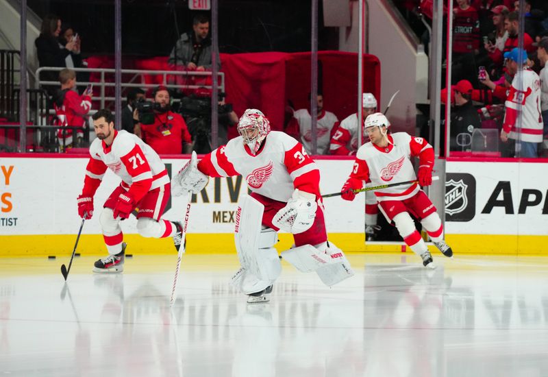 Jan 19, 2024; Raleigh, North Carolina, USA; Detroit Red Wings goaltender Alex Lyon (34) center Dylan Larkin (71) and right wing Alex DeBrincat (93) skate out onto the ice for the warmups before the game against the Carolina Hurricanes at PNC Arena. Mandatory Credit: James Guillory-USA TODAY Sports