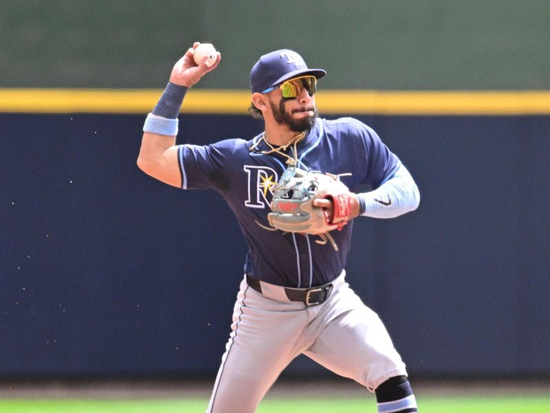 May 1, 2024; Milwaukee, Wisconsin, USA; Tampa Bay Rays shortstop José Caballero (7) fields the ball and throws to first base against the Milwaukee Brewers in the second inning at American Family Field. Mandatory Credit: Michael McLoone-USA TODAY Sports