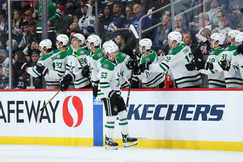 Nov 11, 2023; Winnipeg, Manitoba, CAN;  Dallas Stars forward Wyatt Johnston (53) is congratulated by his teammates on his goal against the Winnipeg Jets during the second period at Canada Life Centre. Mandatory Credit: Terrence Lee-USA TODAY Sports