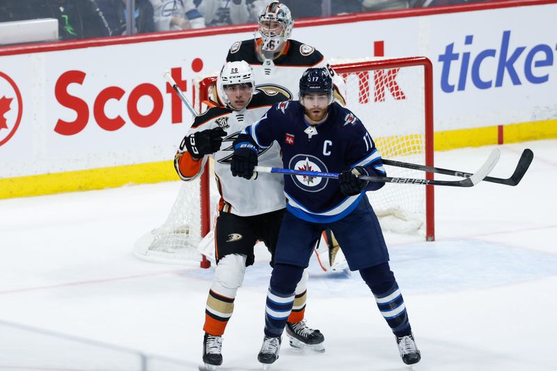 Mar 15, 2024; Winnipeg, Manitoba, CAN; Anaheim Ducks forward Brett Leason (20) jostles for position with Winnipeg Jets forward Adam Lowry (17) during the third period at Canada Life Centre. Mandatory Credit: Terrence Lee-USA TODAY Sports