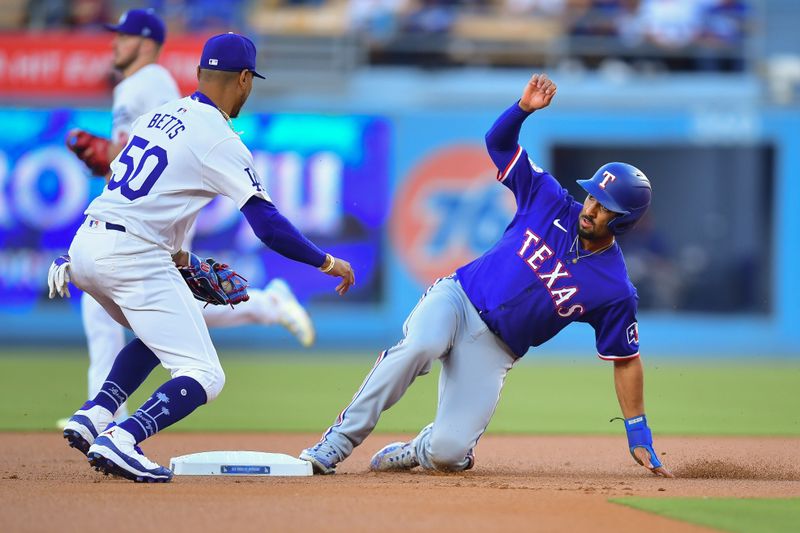 Jun 12, 2024; Los Angeles, California, USA; Texas Rangers second baseman Marcus Semien (2) reaches second against Los Angeles Dodgers shortstop Mookie Betts (50). during the first inning at Dodger Stadium. Mandatory Credit: Gary A. Vasquez-USA TODAY Sports