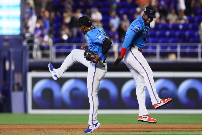 Jul 21, 2024; Miami, Florida, USA; Miami Marlins right fielder Jesus Sanchez (12) and shortstop Otto Lopez (61) celebrate after the game against the New York Mets at loanDepot Park. Mandatory Credit: Sam Navarro-USA TODAY Sports