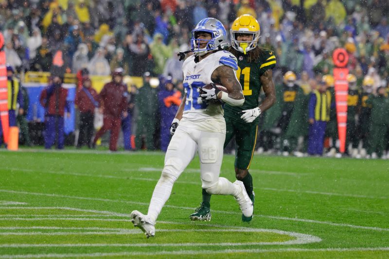 Detroit Lions running back Jahmyr Gibbs (26) scores a rushing touchdown past Green Bay Packers cornerback Eric Stokes during the second half of an NFL football game Sunday, Nov. 3, 2024, in Green Bay, Wis. (AP Photo/Matt Ludtke)