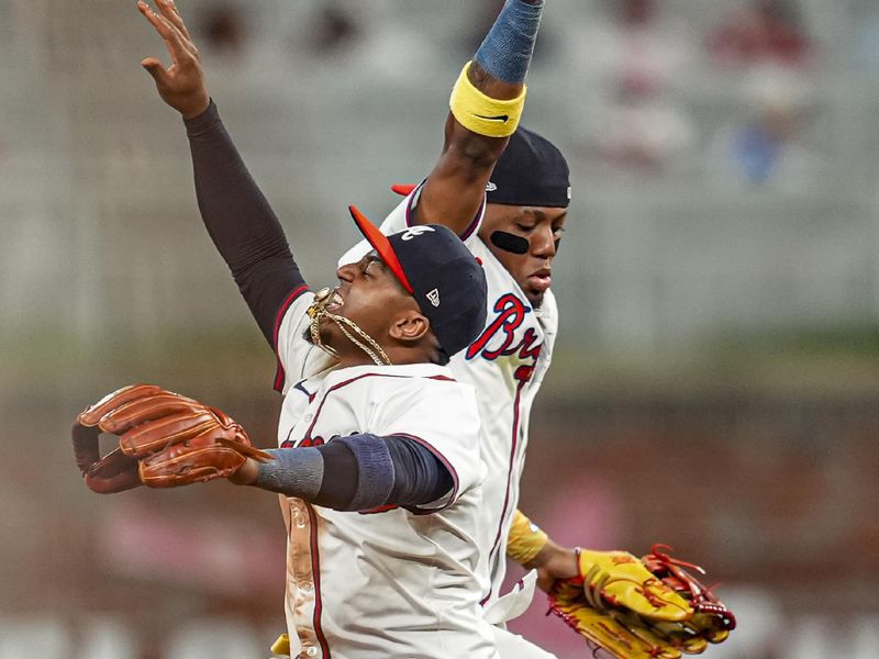 May 14, 2024; Cumberland, Georgia, USA; Atlanta Braves second baseman Ozzie Albies (1) and right fielder Ronald Acuna Jr (13) react after the Braves defeated the Chicago Cubs at Truist Park. Mandatory Credit: Dale Zanine-USA TODAY Sports