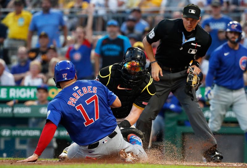 Aug 27, 2024; Pittsburgh, Pennsylvania, USA;  Chicago Cubs third baseman Isaac Paredes (17) slides home to score a run against Pittsburgh Pirates catcher Henry Davis (middle) during the fourth inning at PNC Park. Mandatory Credit: Charles LeClaire-USA TODAY Sports