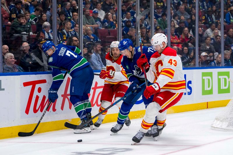 Oct 9, 2024; Vancouver, British Columbia, CAN; Calgary Flames forward Ryan Lomberg (70) and Vancouver Canucks defenseman Carson Soucy (7) watch as defenseman Vincent Desharnais (73) battles with forward Adam Klapka (43) during the third period at Rogers Arena. Mandatory Credit: Bob Frid-Imagn Images