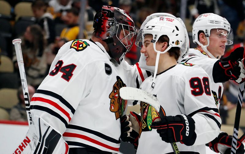 Oct 10, 2023; Pittsburgh, Pennsylvania, USA; Chicago Blackhawks goaltender Petr Mrazek (34) and center Connor Bedard (98) celebrate after defeating the Pittsburgh Penguins at the PPG Paints Arena. Chicago won 4-2. Mandatory Credit: Charles LeClaire-USA TODAY Sports