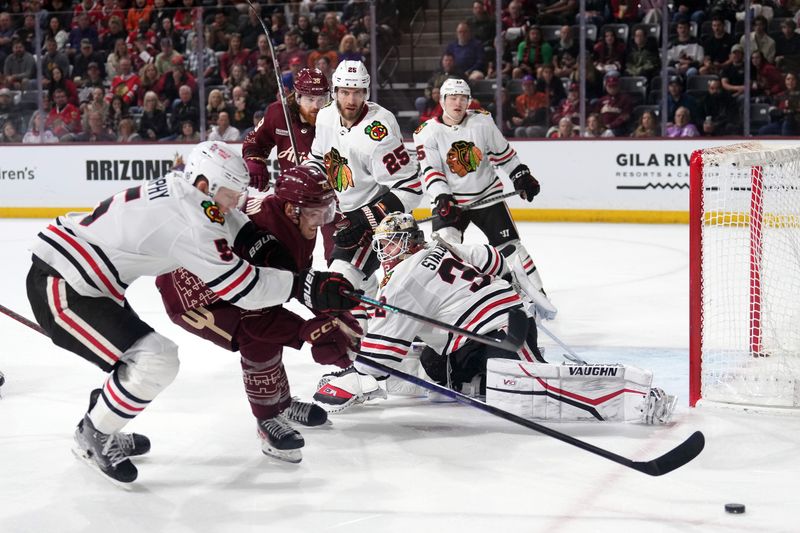 Mar 18, 2023; Tempe, Arizona, USA; Chicago Blackhawks goaltender Alex Stalock (32) watches as Chicago Blackhawks defenseman Connor Murphy (5) and Arizona Coyotes center Laurent Dauphin (26) go after a loose puck during the second period at Mullett Arena. Mandatory Credit: Joe Camporeale-USA TODAY Sports