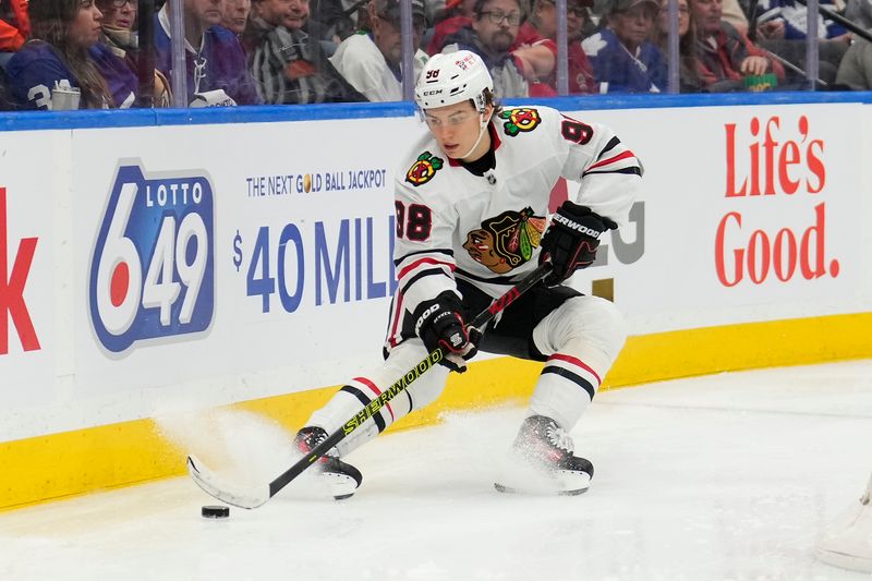 Dec 2, 2024; Toronto, Ontario, CAN; Chicago Blackhawks forward Connor Bedard (98) controls the puck against the Toronto Maple Leafs during the second period at Scotiabank Arena. Mandatory Credit: John E. Sokolowski-Imagn Images