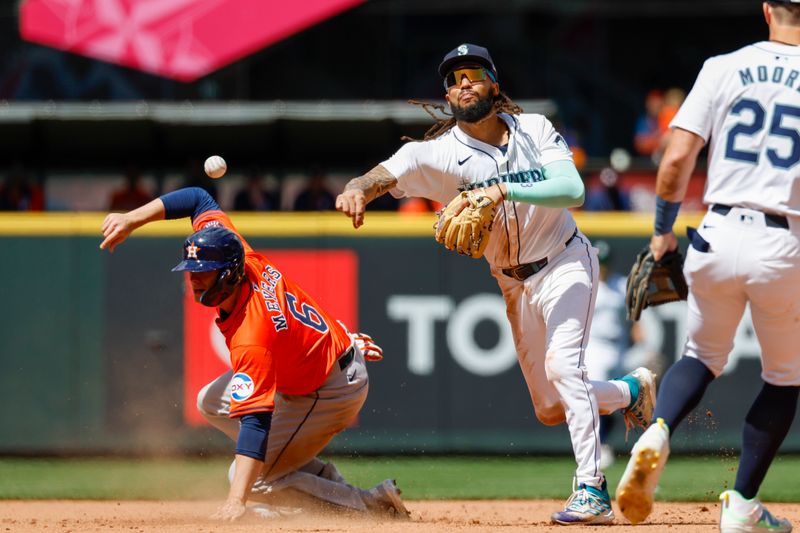 May 30, 2024; Seattle, Washington, USA; Seattle Mariners shortstop J.P. Crawford (3) attempts to turn a double play after getting a force-out against Houston Astros center fielder Jake Meyers (6) during the sixth inning at T-Mobile Park. The throw was late to first base, allowing a run to score for the Astros. Mandatory Credit: Joe Nicholson-USA TODAY Sports