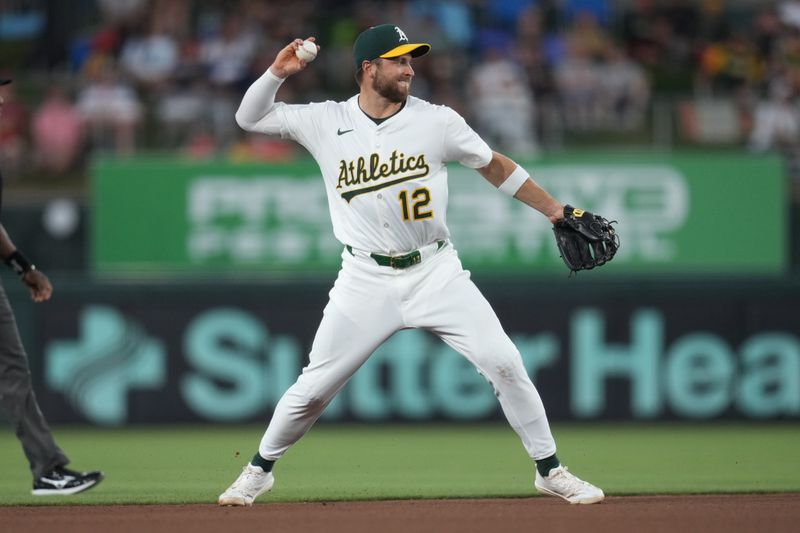 May 21, 2025; West Sacramento, California, USA; Athletics shortstop Max Schuemann (12) throws to first for an out against the Los Angeles Angels in the fourth inning at Sutter Health Park. Mandatory Credit: Cary Edmondson-Imagn Images