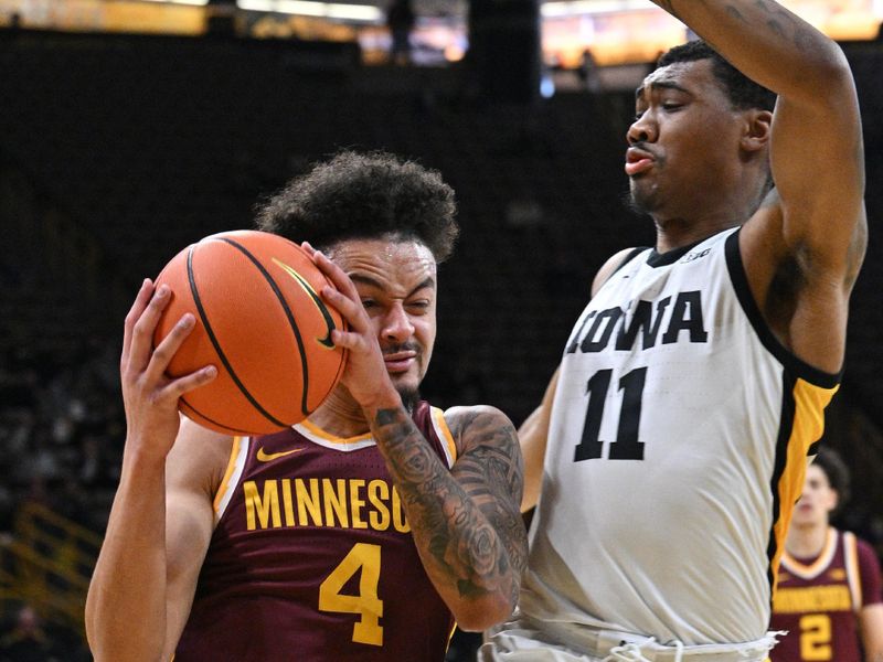 Feb 11, 2024; Iowa City, Iowa, USA; Minnesota Golden Gophers guard Braeden Carrington (4) is defended by Iowa Hawkeyes guard Tony Perkins (11)  during the first half at Carver-Hawkeye Arena. Mandatory Credit: Jeffrey Becker-USA TODAY Sports