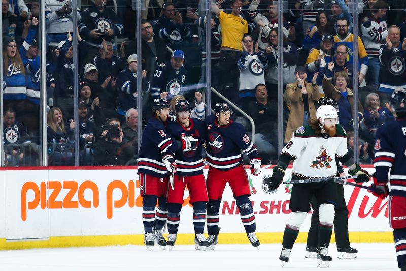 Nov 18, 2023; Winnipeg, Manitoba, CAN; Winnipeg Jets forward Mark Scheifele (55) is congratulated by his team mates on his goal against the Arizona Coyotes during the first period at Canada Life Centre. Mandatory Credit: Terrence Lee-USA TODAY Sports