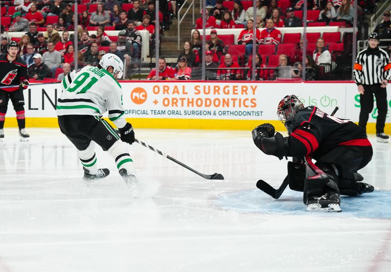 Nov 25, 2024; Raleigh, North Carolina, USA;  Dallas Stars center Tyler Seguin (91) takes a shot at Carolina Hurricanes goaltender Spencer Martin (41) during the second period at Lenovo Center. Mandatory Credit: James Guillory-Imagn Images