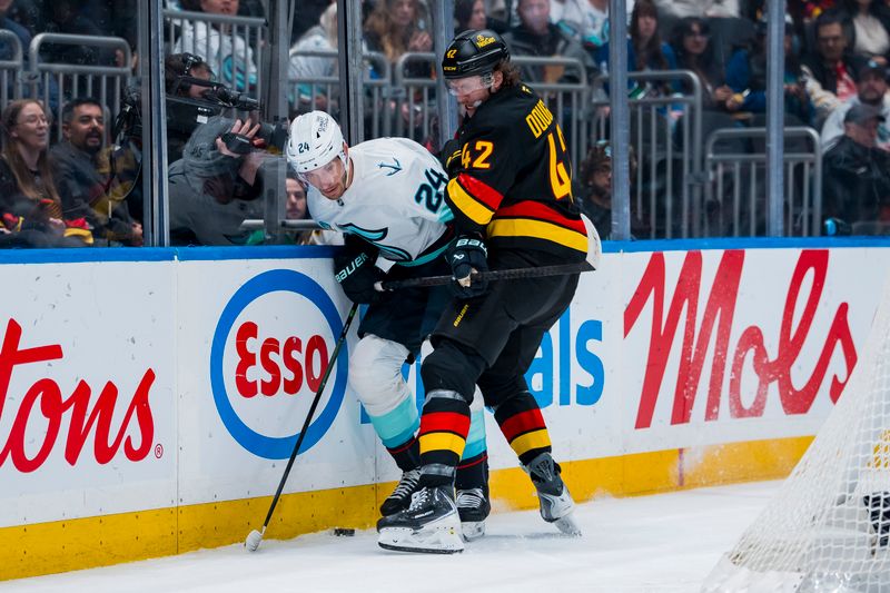 Mar 14, 2026; Vancouver, British Columbia, CAN; Vancouver Canucks forward Curtis Douglas (42) checks Seattle Kraken defenseman Jamie Oleksiak (24) in the second period at Rogers Arena. Mandatory Credit: Bob Frid-Imagn Images