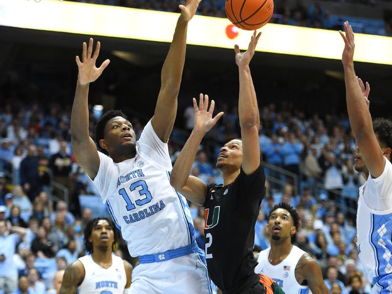 Feb 13, 2023; Chapel Hill, North Carolina, USA; Miami (Fl) Hurricanes guard Isaiah Wong (2) shoots as North Carolina Tar Heels forward Jalen Washington (13) defends in the first half at Dean E. Smith Center. Mandatory Credit: Bob Donnan-USA TODAY Sports