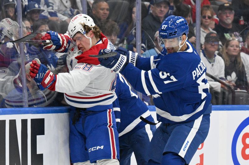 Sep 26, 2024; Toronto, Ontario, CAN;  Toronto Maple Leafs forward Max Pacioretty (67) bodychecks Montreal Canadiens forward Christian Dvorak (28) in the first period at Scotiabank Arena. Mandatory Credit: Dan Hamilton-Imagn Images