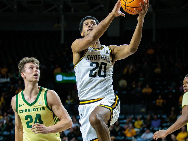 Jan 14, 2025; Wichita, Kansas, USA; Wichita State Shockers guard Harlond Beverly (20) drives to the basket around Charlotte 49ers forward Rich Rolf (24) during the second half at Charles Koch Arena. Mandatory Credit: William Purnell-Imagn Images