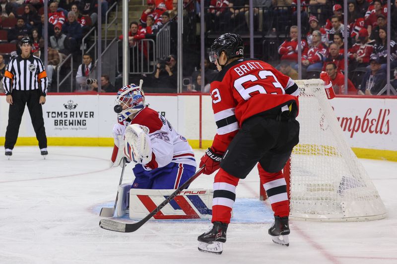 Nov 7, 2024; Newark, New Jersey, USA; Montreal Canadiens goaltender Sam Montembeault (35) makes a save while New Jersey Devils left wing Jesper Bratt (63) looks for the puck during the second period at Prudential Center. Mandatory Credit: Ed Mulholland-Imagn Images